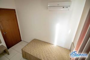 a small room with a bed and a air conditioner at Riviera Park in Caldas Novas