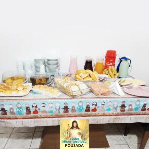 una mesa con comida y estatuillas. en Pousada Jesus Misericordioso, en Aparecida