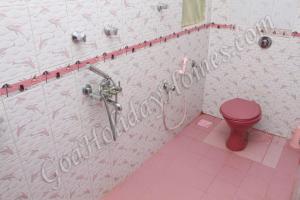a bathroom with a pink toilet and a shower at Shalom Dream Home in Candolim +20 photos
