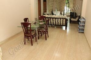 a dining room with a glass table and chairs at Shalom Dream Home in Candolim