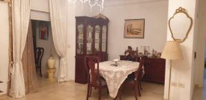 a dining room with a table and a dresser at SUPER APART A CITE EL KHADHRA in Tunis