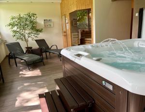 a bathroom with a tub with chairs and a table at Landferien Eifel in Pittenbach +36 photos