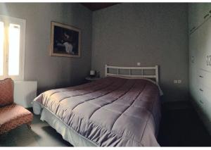 um quarto com uma cama grande e uma cadeira em Artemis House em Krokeaí