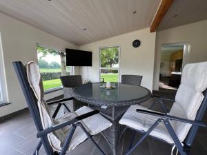 a dining room with a glass table and chairs at Landferien Eifel in Pittenbach