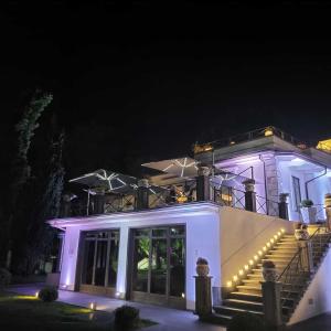 a white house with stairs and lights at night at Villa Minieri Resort & SPA in Nola