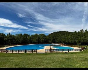 a large blue swimming pool with a fence around it at El rincón de los Lanchares in Sotillo de la Adrada
