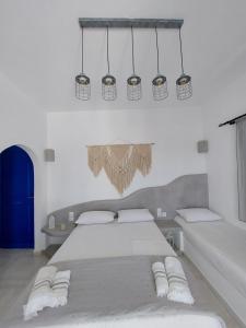 a bedroom with a large bed and a chandelier at Anemelia Hotel Adamas in Adamantas