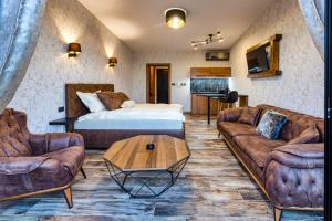 a living room with a bed and two couches at Apartmani Tiske noći in Bečej