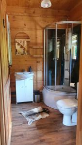 a bathroom with a tub and a toilet and a sink at Jodłowa Chata in Myślenice