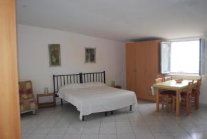 Schlafzimmer mit einem Bett, einem Tisch und einem Fenster in der Unterkunft Villino Castellano Apartments in Meta
