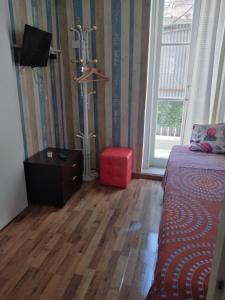 salon z łóżkiem i czerwoną kanapą w obiekcie The Tony w Nikozji