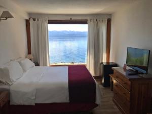 1 dormitorio con cama y vistas al agua en Hostería Nórdico Lake by Nordic en San Carlos de Bariloche