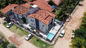 una casa grande con coches estacionados frente a ella en Flat Beira-Mar Maragogi, en Maragogi