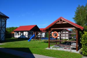 a park with a playground and a pavilion at Letnia Przystań in Rusinowo