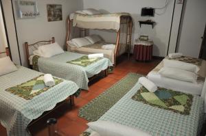 a room with three beds and a table at Hospedaje La Casona in Tabio