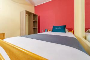 una camera con un letto con una parete rossa di Ayenda Muñoz a Ica