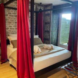 FléacにあるLe Maine N 5 - FLÉAC ANGOULEME - Suite Harry Potterのベッドルーム1室(赤いカーテン付きのベッド1台付)