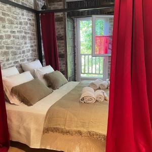 FléacにあるLe Maine N 5 - FLÉAC ANGOULEME - Suite Harry Potterのベッドルーム1室(赤いカーテン付きの大型ベッド1台付)