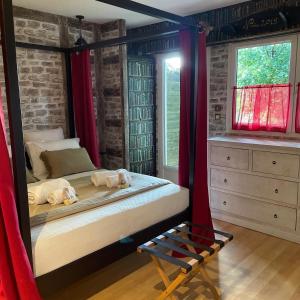FléacにあるLe Maine N 5 - FLÉAC ANGOULEME - Suite Harry Potterのベッドルーム1室(赤いカーテンと鏡付きのベッド1台付)