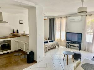 - un salon avec une télévision et un lit dans l'établissement Appartement confortable près de la plage Catalane et Pharo, à Marseille