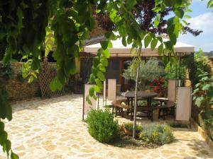 un patio con mesa y sillas en un jardín en Casa rural La antigua botiga en La Iglesuela del Cid