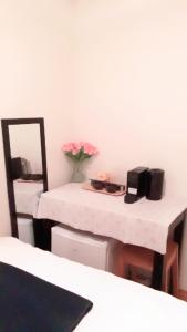 a room with a table with a vase of flowers on it at Budget Little Room with Window City Centre Oslo in Oslo +6 photos