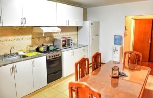 a kitchen with a wooden table and white cabinets at Departamento Centro con cochera gratis in Paraná