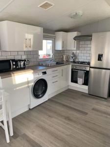 惠斯塔布的住宿－Alberta holiday park，厨房配有白色橱柜、洗衣机和烘干机