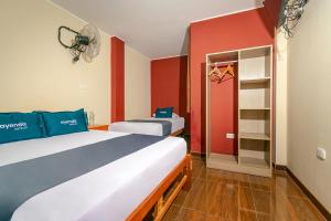 1 Schlafzimmer mit 2 Betten und einem Schrank mit einem Ventilator in der Unterkunft Ayenda Muñoz in Ica