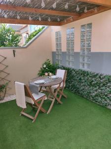 エル・メダノにあるAvenue Studyの緑の芝生のあるパティオ(テーブル、椅子付)