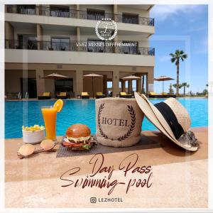 a sign that says day pass swimming pool with a hamburger and drink at Z Hotel Meknes in Meknès