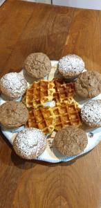 een bord koekjes en wafels op een houten tafel bij Le Nichoir in Lion-en-Sullias