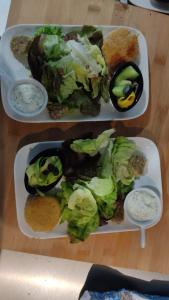 dois pratos de comida numa mesa com salada e molho em Le Nichoir em Lion-en-Sullias