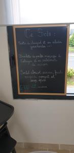 un tableau noir avec écriture sur un mur dans l'établissement Le Nichoir, à Lion-en-Sullias