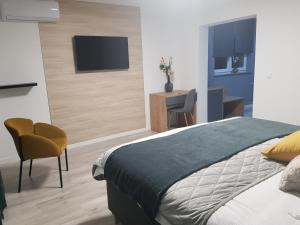 a bedroom with a bed and a desk and a tv at Rooms Vanteo in Korenica