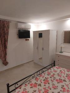 um quarto com uma cama e uma televisão na parede em Mivigio em Bari