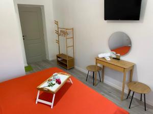 a room with a table and a mirror and a table with flowers at Glam Boutique in Mangalia