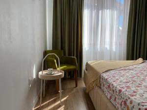 a bedroom with a bed and a table and a chair at Glam Boutique in Mangalia