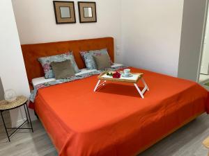 a bed with an orange blanket and a table on it at Glam Boutique in Mangalia +13 photos