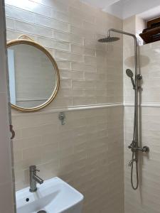 a bathroom with a sink and a shower with a mirror at Glam Boutique in Mangalia