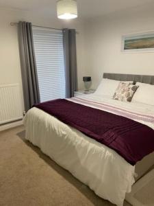 a bedroom with a large bed and a window at Burlington Cottage - Ulverston, Lake District. in Ulverston