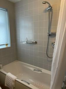 a bathroom with a shower and a bath tub at Burlington Cottage - Ulverston, Lake District. in Ulverston