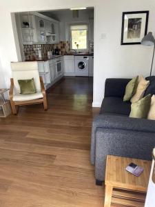 a living room with a couch and a kitchen at Burlington Cottage - Ulverston, Lake District. in Ulverston