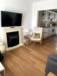 a living room with a fireplace and a flat screen tv at Burlington Cottage - Ulverston, Lake District. in Ulverston