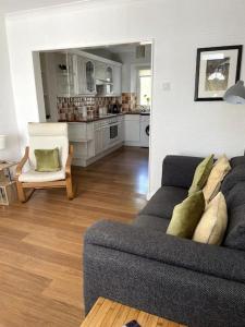 a living room with a couch and a kitchen at Burlington Cottage - Ulverston, Lake District. in Ulverston