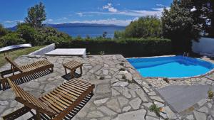a patio with two chairs and a swimming pool at Hostería Nórdico Lake by Nordic in San Carlos de Bariloche
