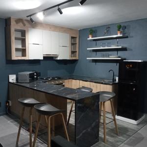 a kitchen with a black counter and stools at Durban Beachfront 10 South Apartments 1404 in Durban
