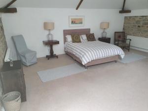 a bedroom with a bed and a chair in it at The Granary in Tullow