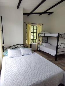 a bedroom with a large white bed and a window at CASALOMA in La Vega