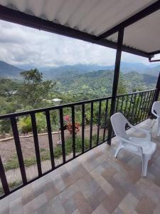 a balcony with two chairs and a view of the mountains at CASALOMA in La Vega